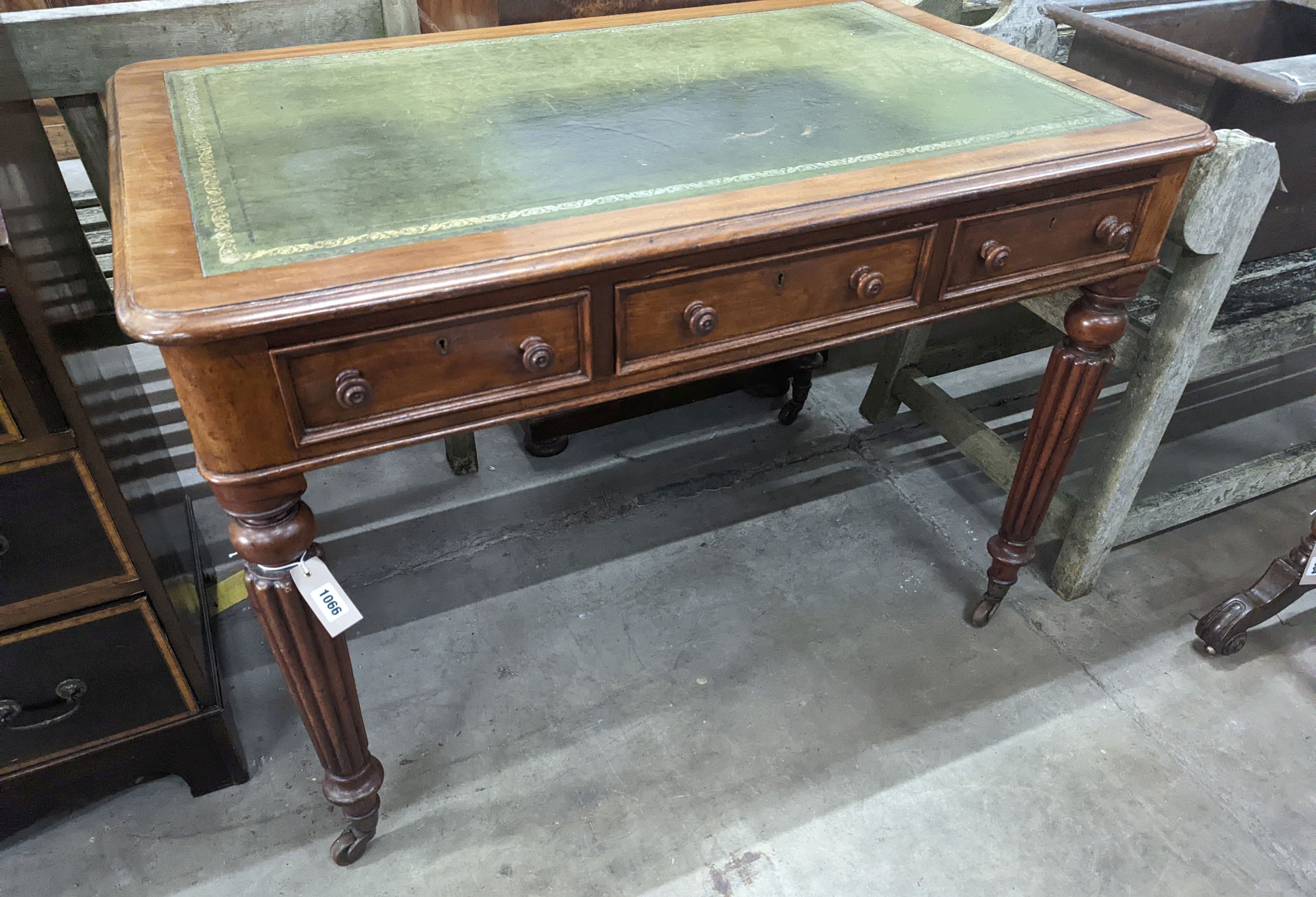 A Victorian mahogany three drawer writing table on fluted legs, width 106cm, depth 66cm, height 75cm